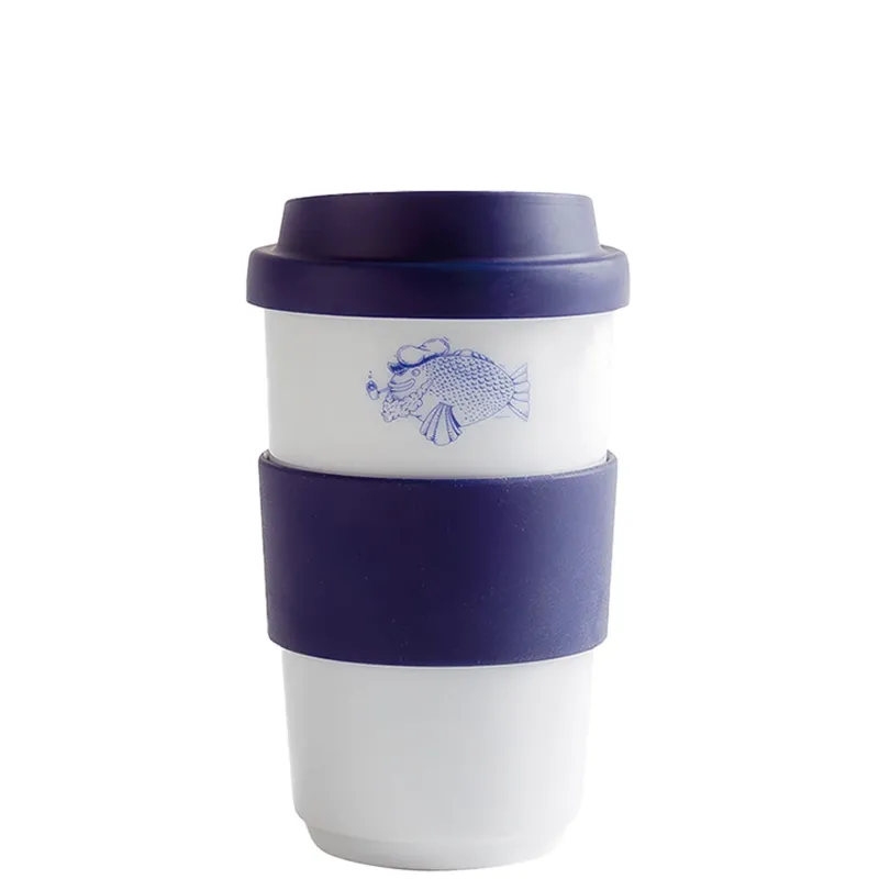Ein erneut benutzbarer Kaffeebecher aus weißem Material mit einem blauen Fischmotiv auf der oberen Hälfte. Der Becher hat einen dunkelblauen Silikonmantel, der als Griff dient und den unteren Bereich schützt. Die Form ist gerade und schlicht, mit einem geschlossenen Deckel. Ideal für umweltbewusste Kaffeetrinker, die ihre Getränke unterwegs genießen möchten.